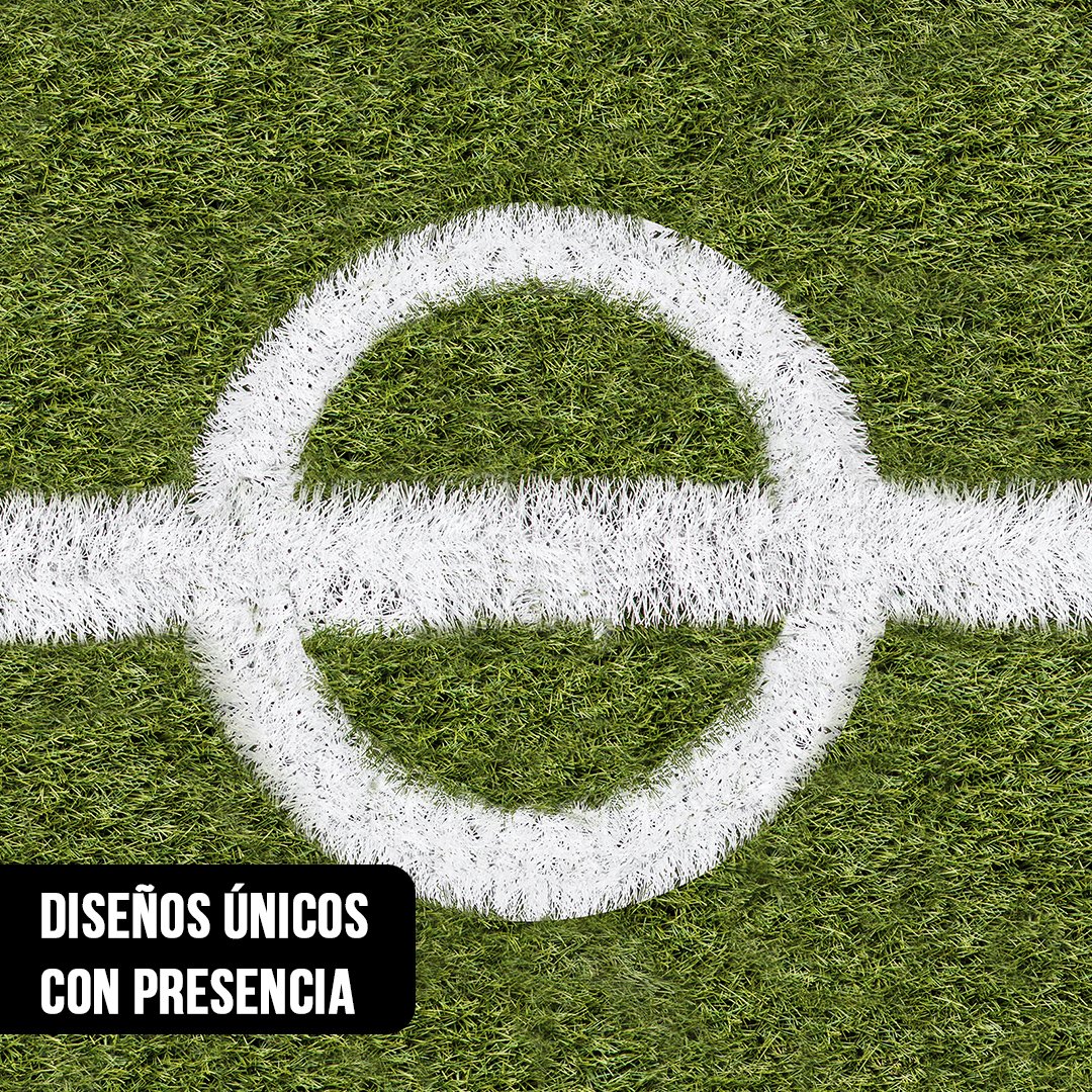 Primer plano del círculo central y la línea media blanca pintada sobre césped verde texturado de una cancha de fútbol