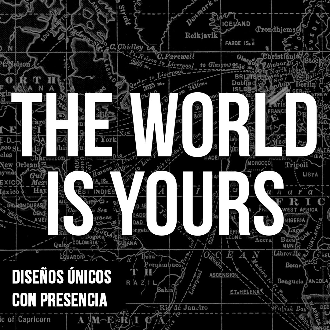 Primer plano de cuadro motivacional con la frase "THE WORLD IS YOURS" en letras blancas gruesas sobre un mapa antiguo detallado en fondo negro