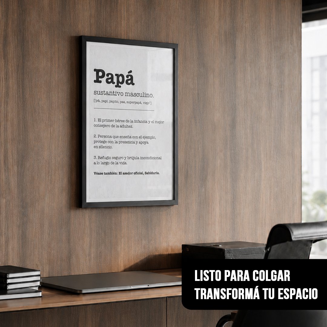 Cuadro vertical enmarcado en negro con la definición de "Papá" colgado sobre un escritorio de madera con una laptop cerrada y una silla de oficina negra
