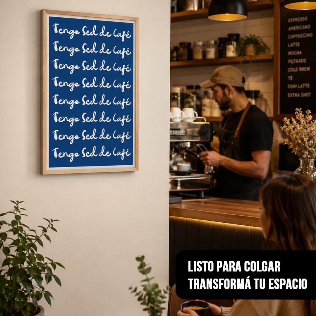 Cuadro vertical con la frase "Tengo Sed de Café" repetida en letras blancas sobre fondo azul con marco de madera clara, colgado en una cafetería junto a la barra de café