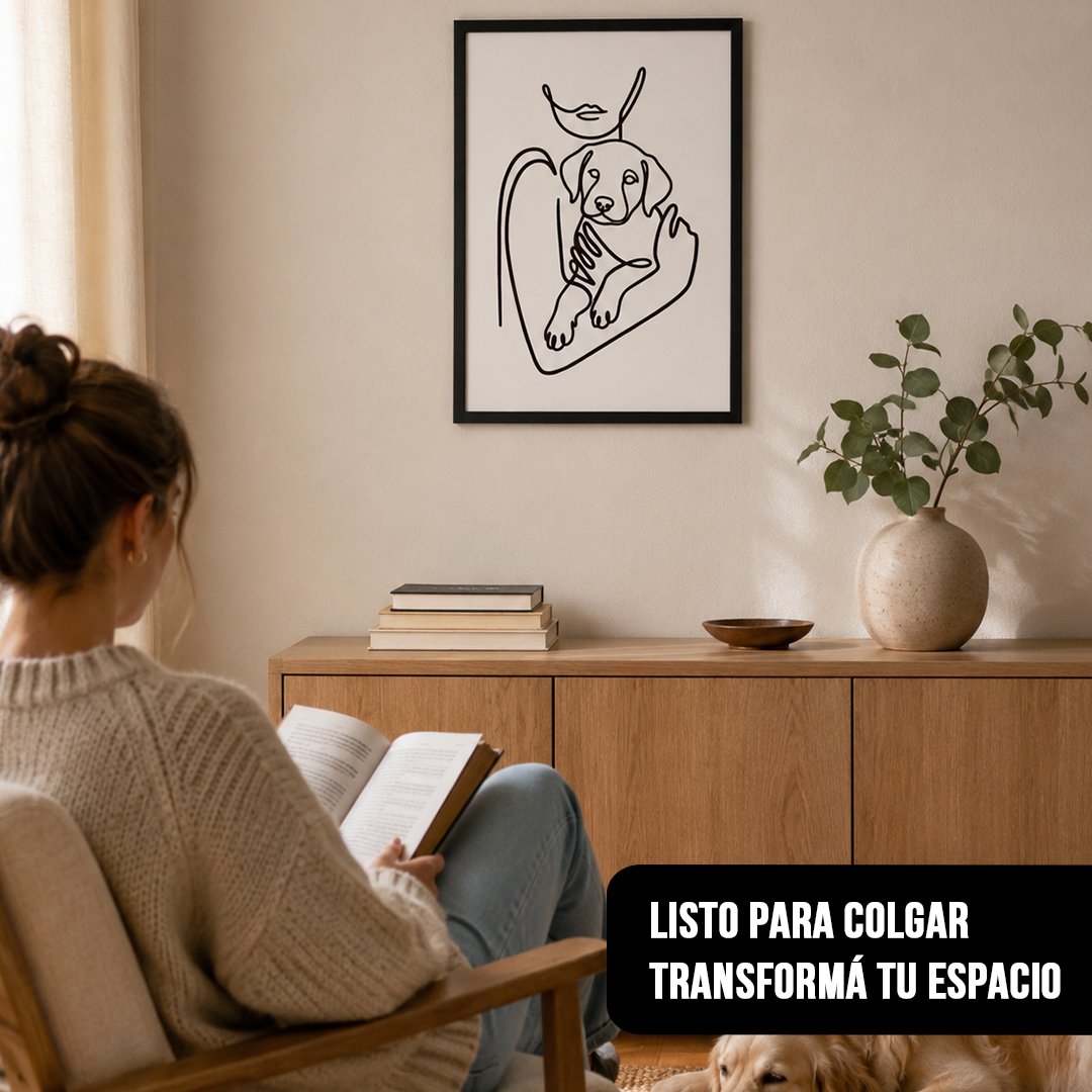 Cuadro vertical de estilo line art de mujer con cachorro en marco negro, colgado sobre un mueble de madera en un living con una persona leyendo