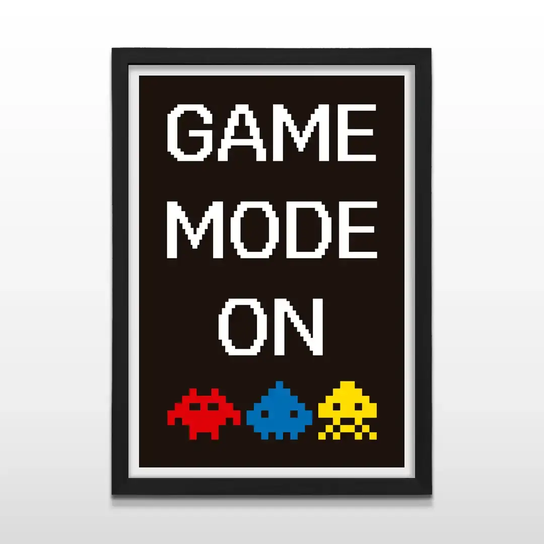 Cuadro moderno Game Mode On con diseño de frase pixelada y monstruos de videojuego clásicos sobre fondo oscuro con marco negro de madera, póster vertical para decoración de setups gamers