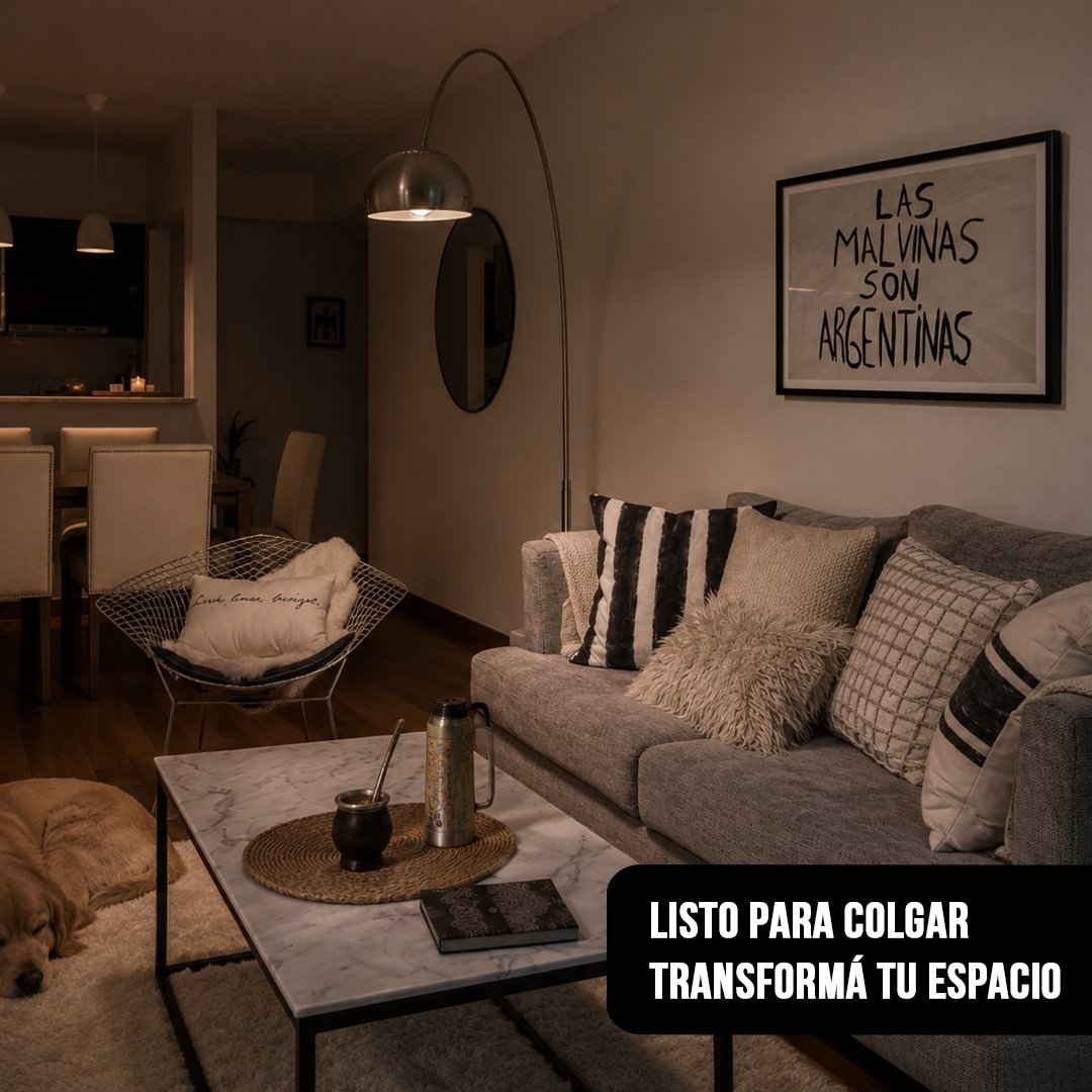 Cuadro horizontal enmarcado en negro con la frase "LAS MALVINAS SON ARGENTINAS" colgado sobre la pared de un living moderno con sillón gris, lámpara de pie y un perro durmiendo