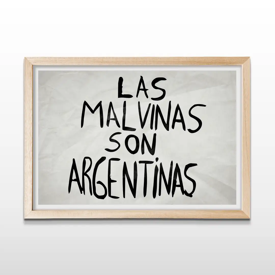 Cuadro horizontal enmarcado en madera clara natural con la frase "LAS MALVINAS SON ARGENTINAS" en letras negras manuscritas sobre fondo blanco texturizado