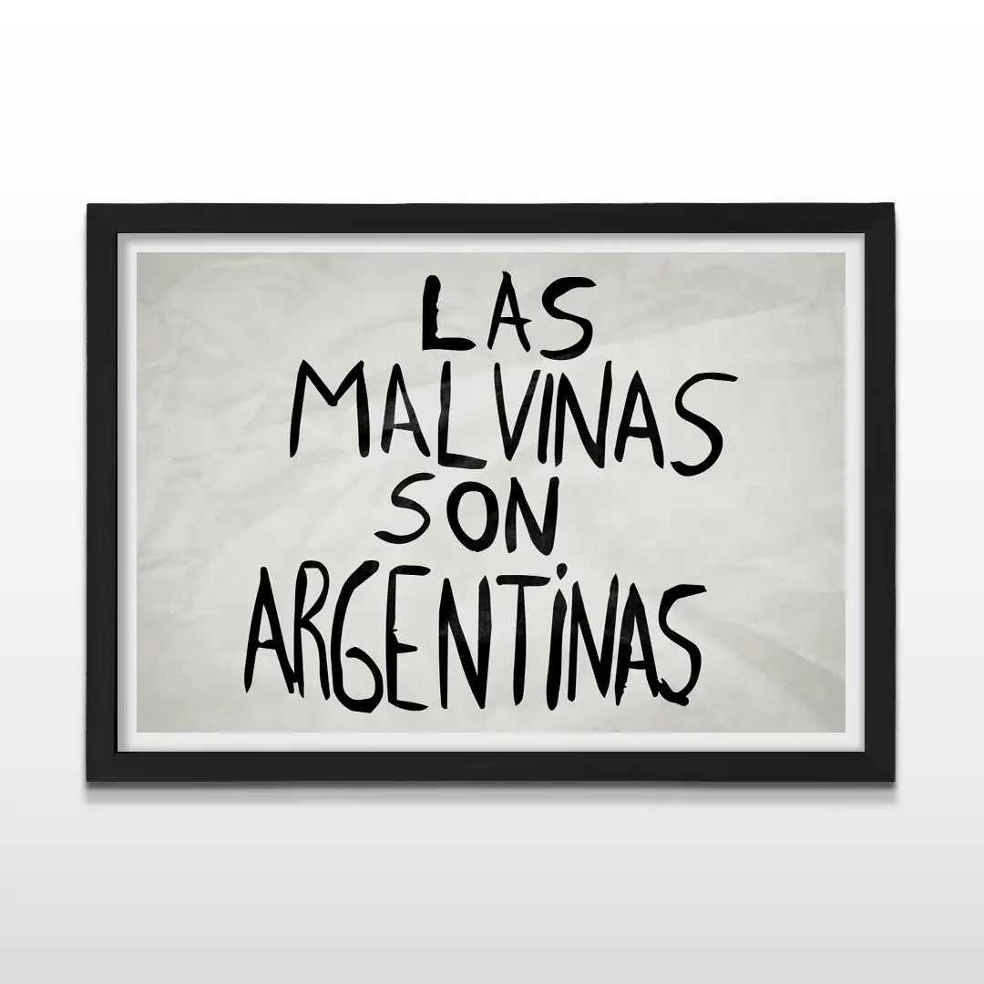 Cuadro horizontal enmarcado en madera negra con la frase "LAS MALVINAS SON ARGENTINAS" escrita en letras mayúsculas negras sobre un fondo blanco con pliegues