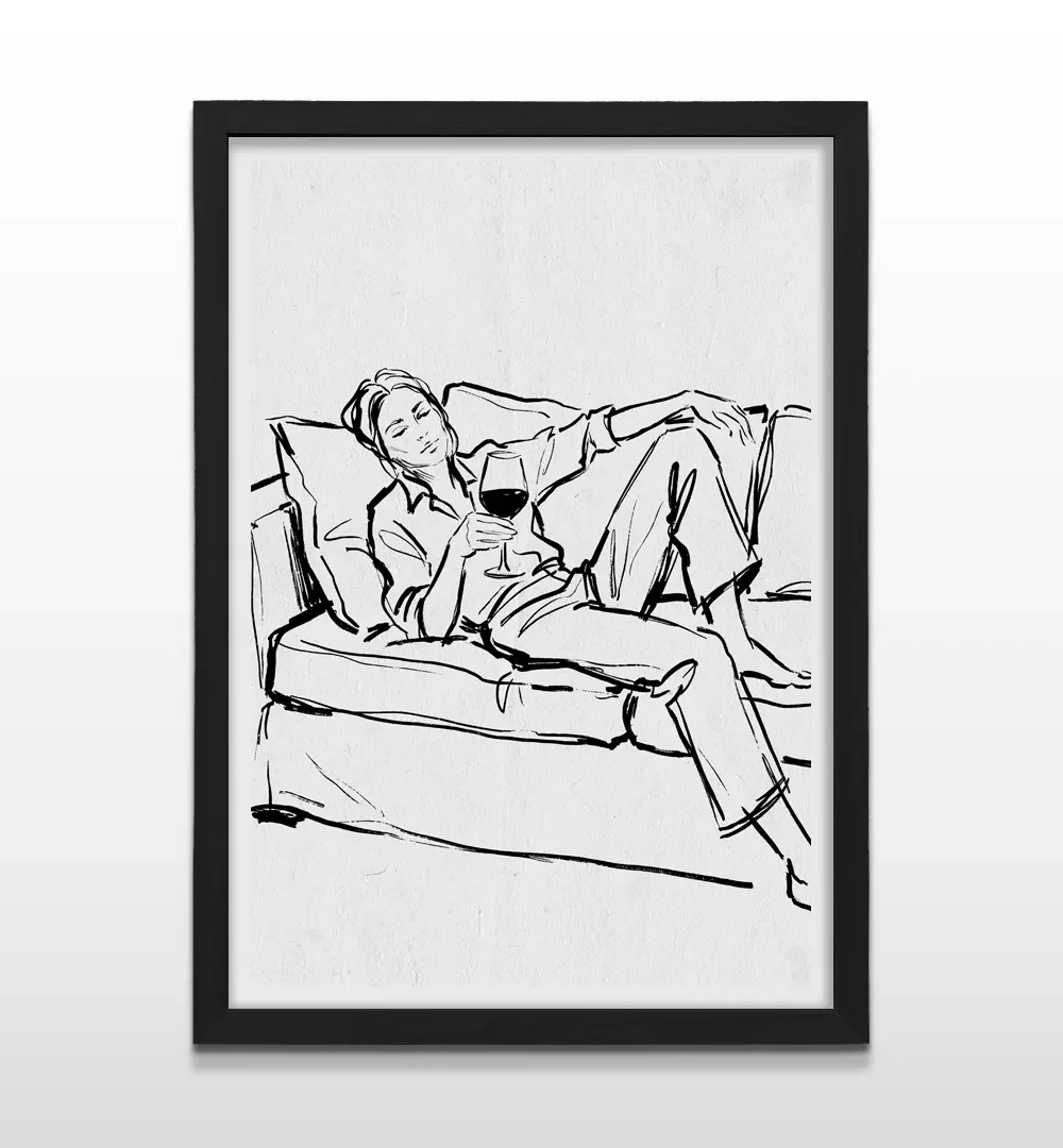 Cuadro vertical en marco negro con ilustración en tinta negra de mujer descansando en un sofá con copa de vino
