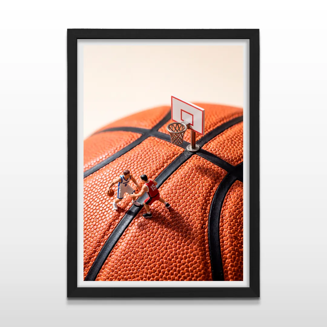 Cuadro vertical en marco negro con lámina fotográfica creativa de partido de básquetbol en miniatura sobre pelota naranja