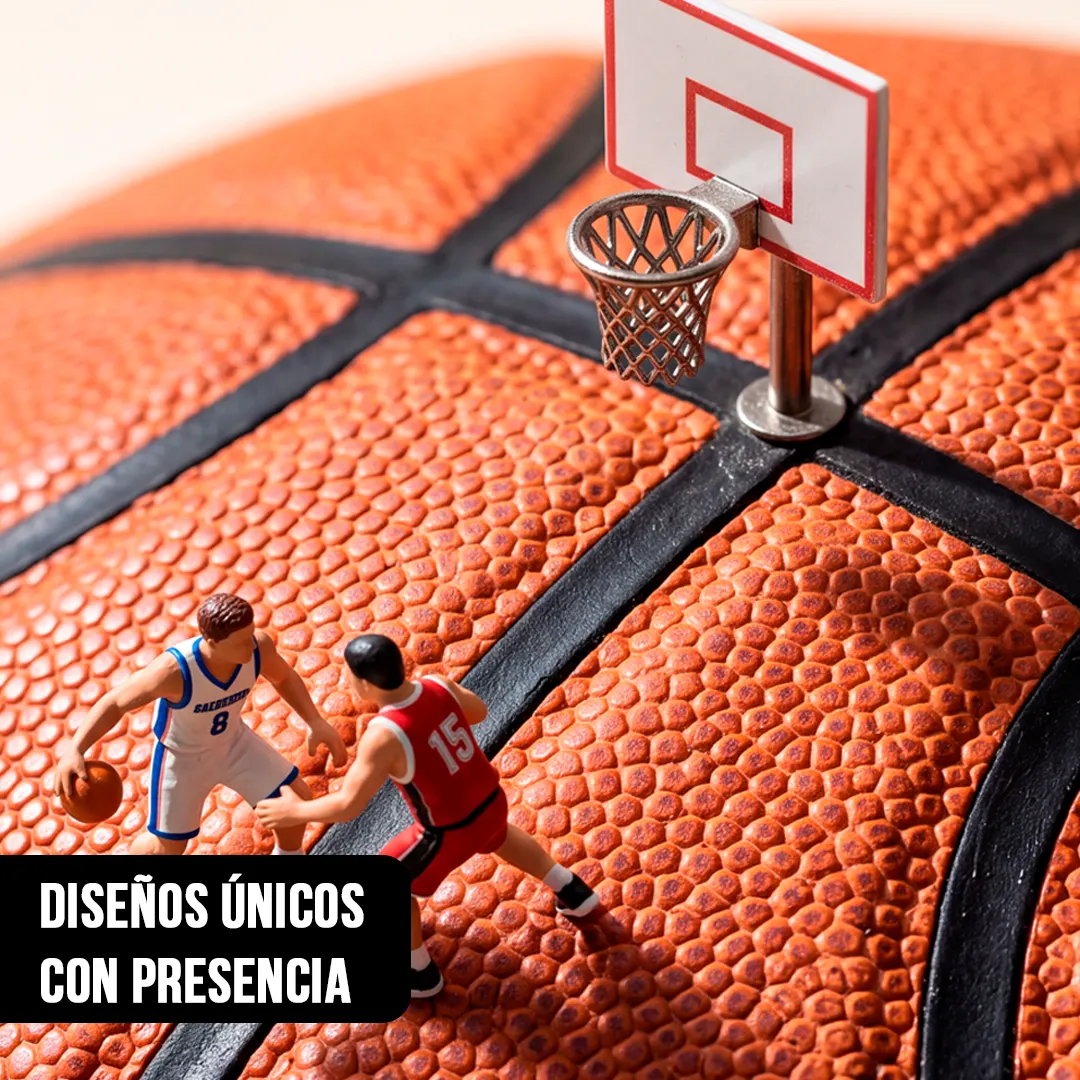 Macrofotografía de dos jugadores en miniatura disputando el balón sobre una pelota de básquetbol con aro diminuto