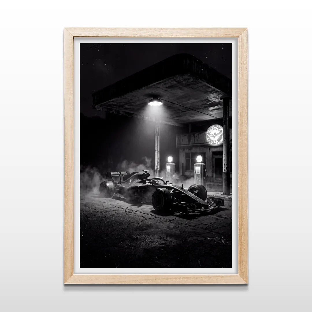 Cuadro vertical en marco de madera clara con imagen cinemática en blanco y negro de auto de Fórmula 1 y surtidores antiguos