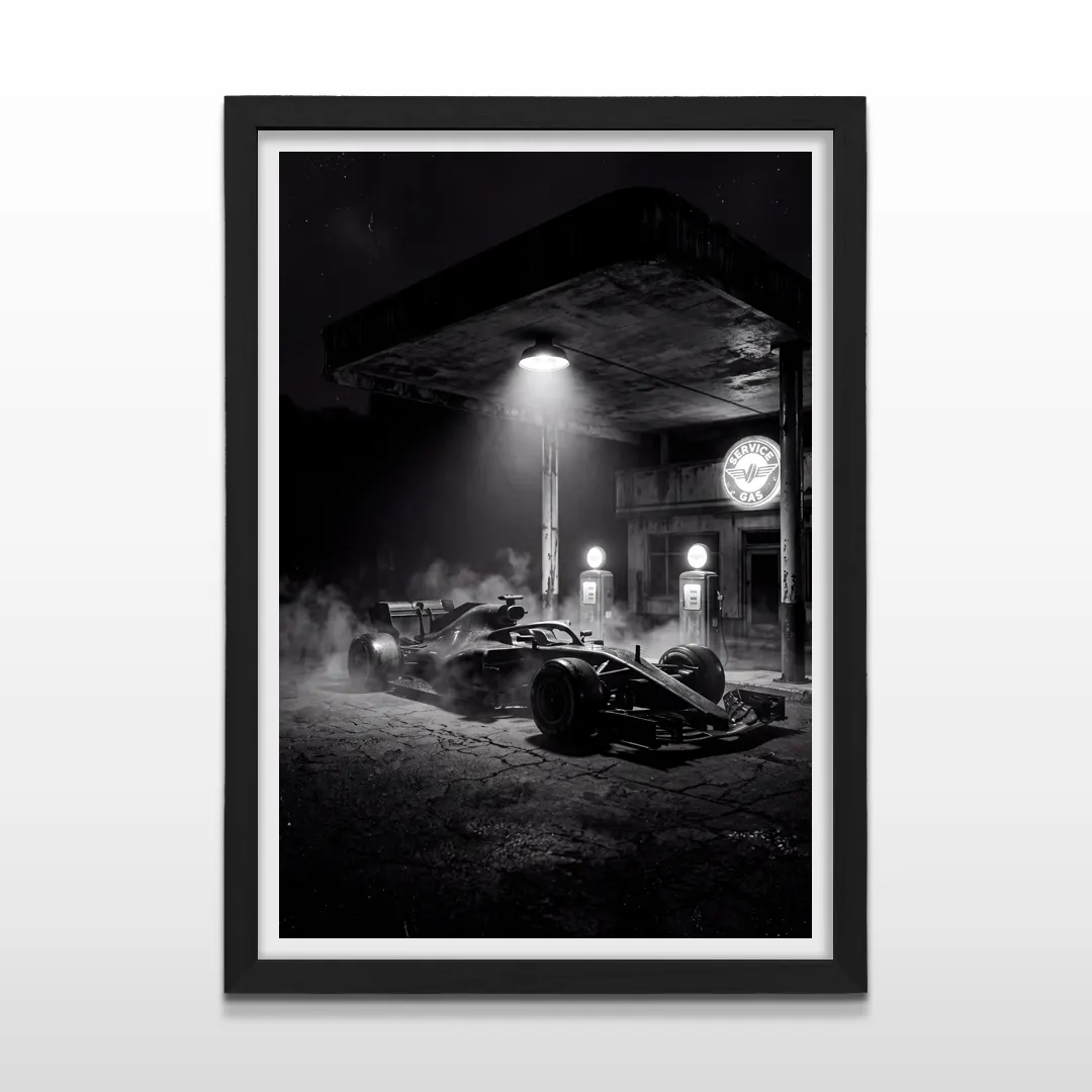 Cuadro vertical en marco negro con lámina fotográfica monocromática de auto de carreras F1 en estación de servicio nocturna